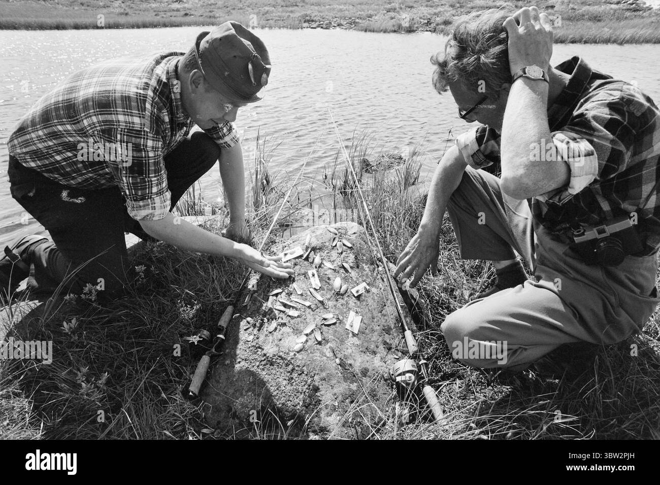 Current 31 - 4 - 1969 : vacances avec un rocher de pêcheSummer en Norvège pour de nombreux pêcheurs, l'un des points forts de l'année est les soirées de juillet au bord d'un lac de montagne lorsque la truite mord volontiers. L'un des grands dilemmes du pêcheur : quels leurres ou quels fileurs doit-il choisir ? Ronny Tollefsbøl (à gauche) se gratte la tête et suggère plutôt des vers de terre. C'est toujours l'appât le plus sûr. Photo : Per Ervik / Current / NTB ***PHOTO NON TRAITÉE*** *texte traduit automatiquement* Banque D'Images