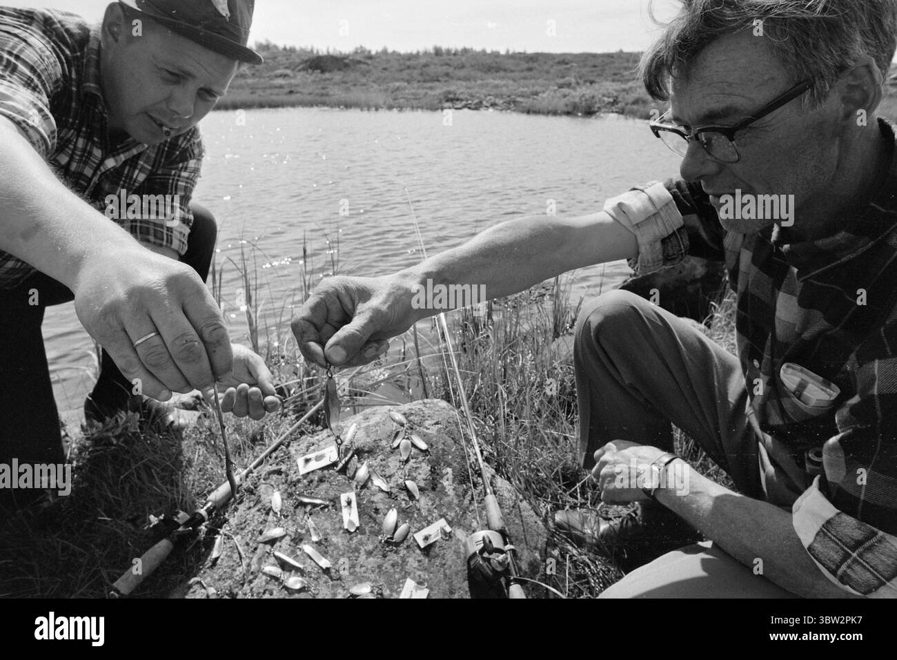 Current 31 - 4 - 1969 : vacances avec un rocher de pêcheSummer en Norvège pour de nombreux pêcheurs, l'un des points forts de l'année est les soirées de juillet au bord d'un lac de montagne lorsque la truite mord volontiers. L'un des grands dilemmes du pêcheur : quels leurres ou quels fileurs doit-il choisir ? Ronny Tollefsbøl (à gauche) se gratte la tête et suggère plutôt des vers de terre. C'est toujours l'appât le plus sûr. Photo : Per Ervik / Current / NTB ***PHOTO NON TRAITÉE*** *texte traduit automatiquement* Banque D'Images
