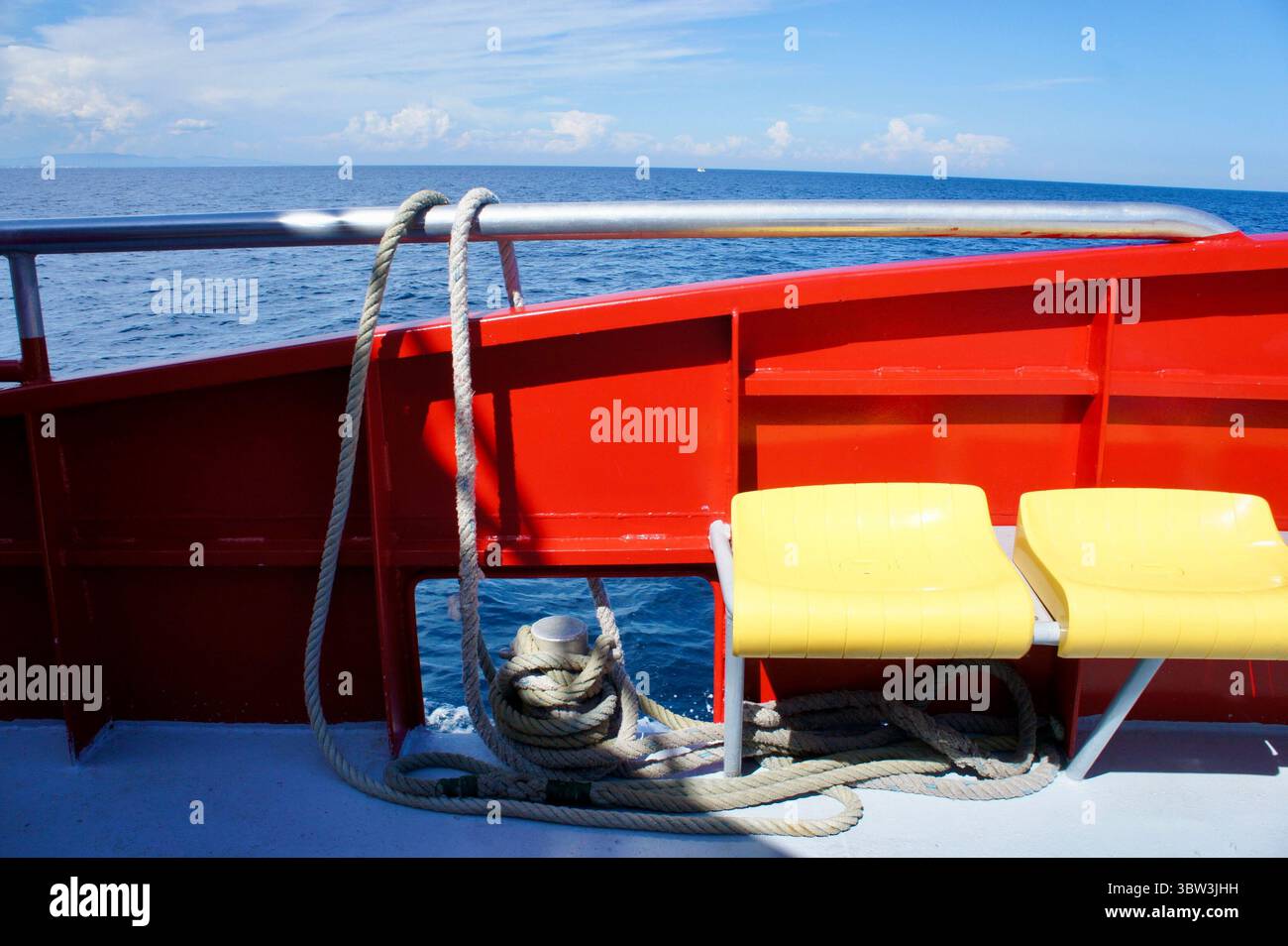 Pont de bateau rouge et sièges jaunes, mer Méditerranée au large de Collioure, France Banque D'Images