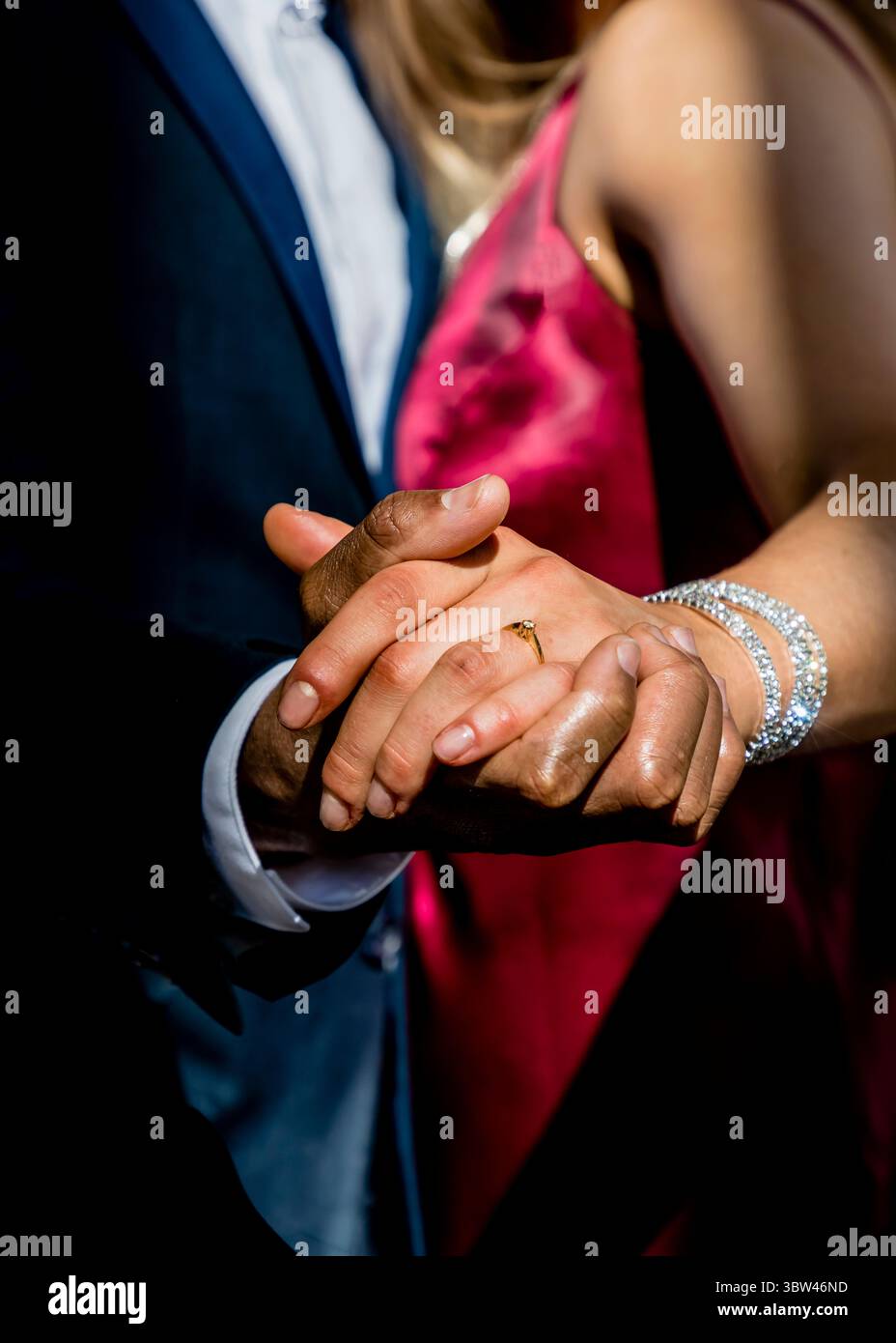 Un couple se tient la main, la femme portant un bracelet en diamant et une bague de fiançailles. Banque D'Images