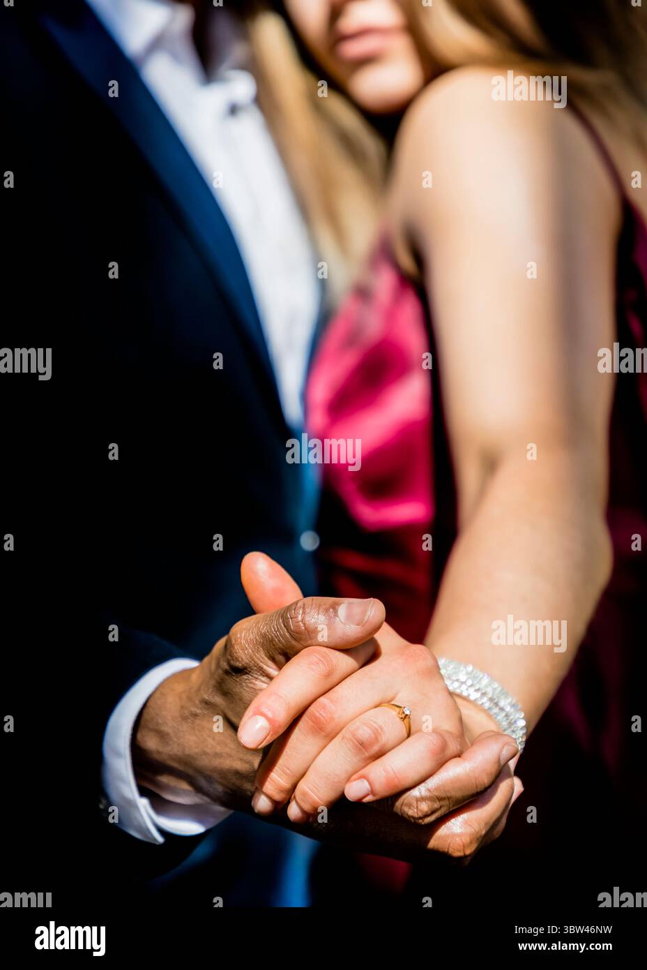 Un couple se tient la main, la femme portant une bague en diamant et un bracelet. Banque D'Images
