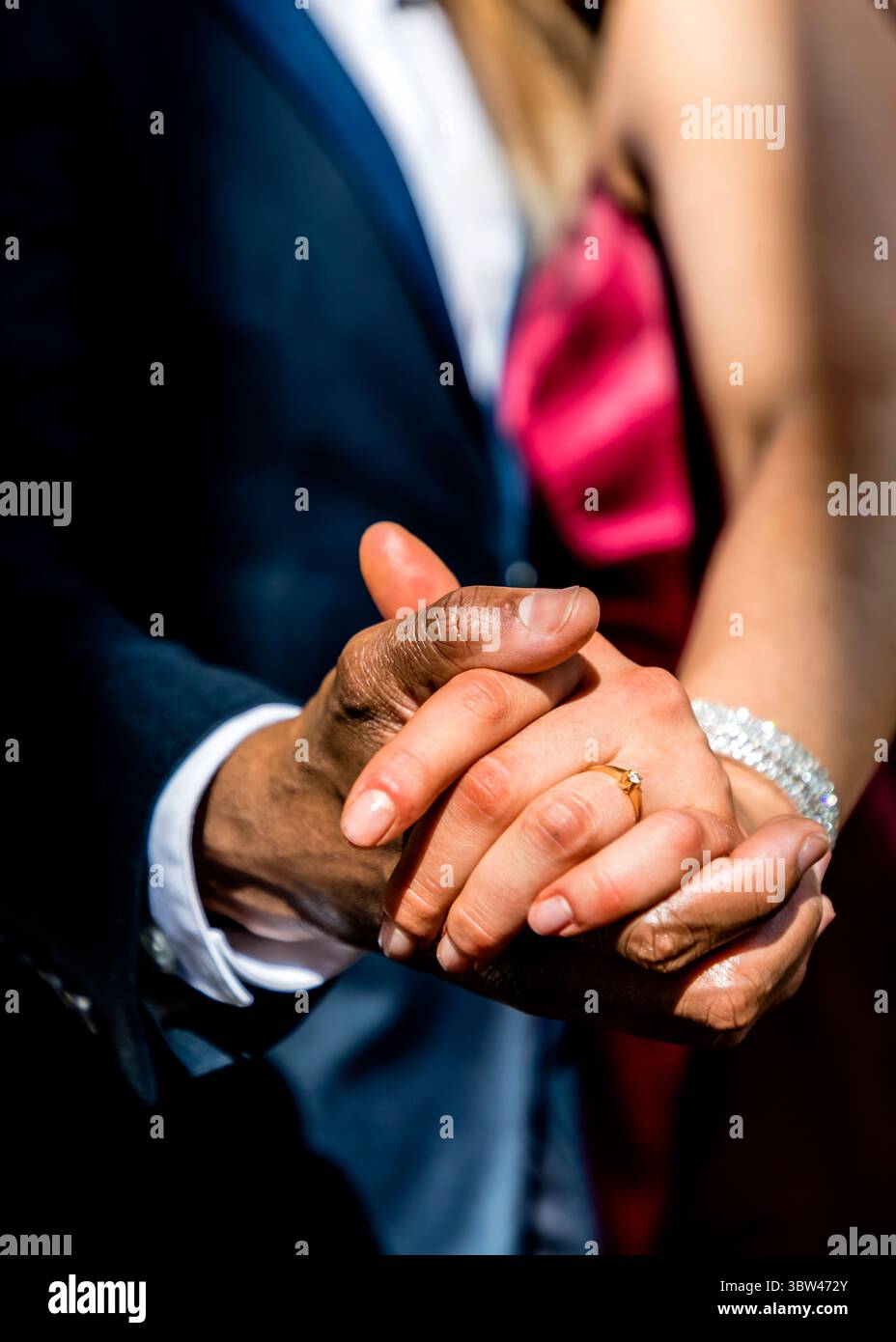 Un couple se tenant la main, la femme portant une bague en diamant et un bracelet. Banque D'Images