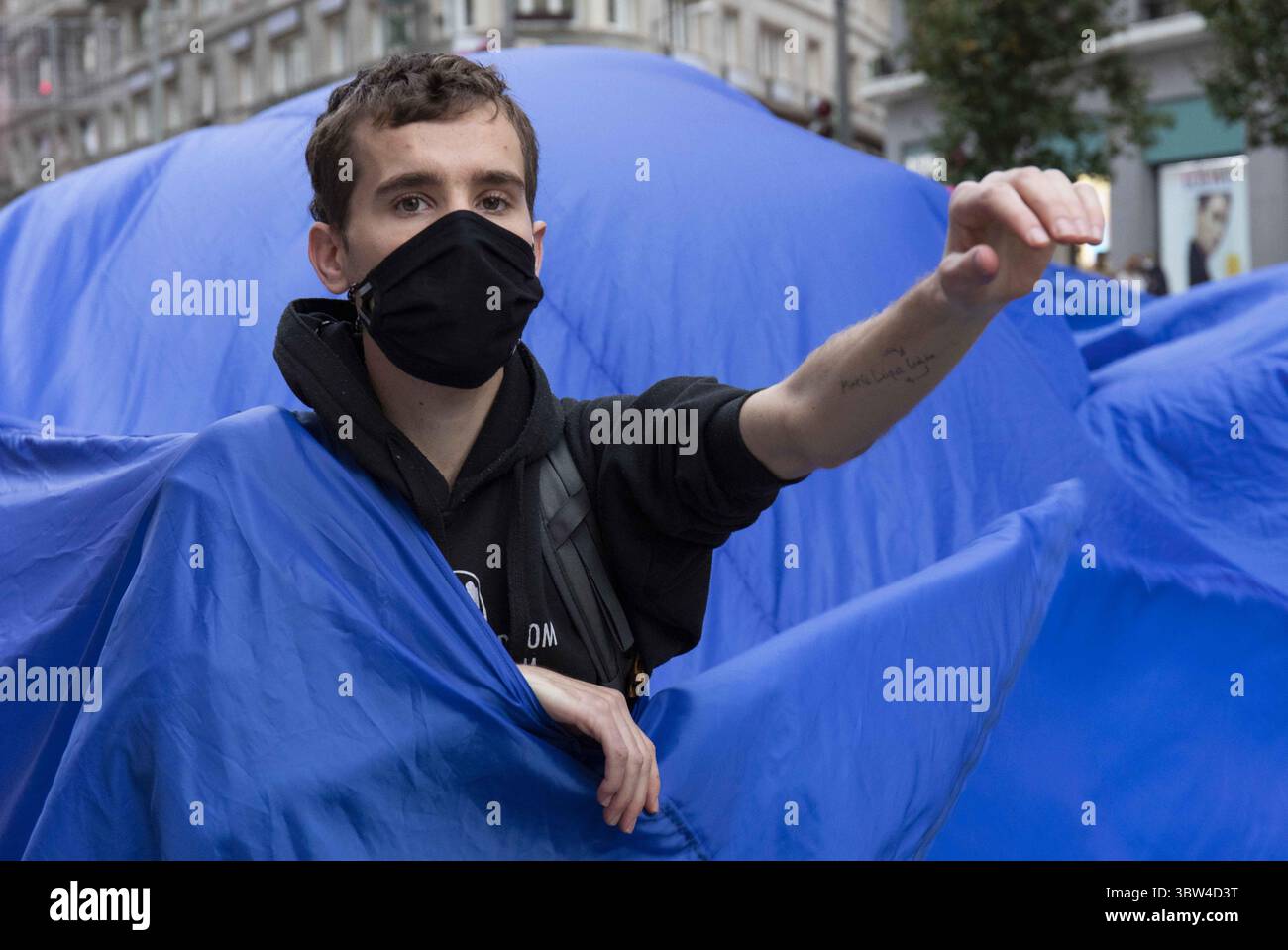 2 novembre 2020, Madrid, Espagne : un activiste portant un masque facial est vu à l'intérieur du tissu bleu pendant la manifestation..pendant la troisième rébellion internationale, le mouvement extinction Rebellion a bloqué la rue Gran VÃ­a à Madrid pour protester contre les conséquences de l'élévation du niveau de la mer. Le mouvement, transportant un tissu bleu de 150 mètres carrés de la place Callao à la place Espagne, marche à travers la rue Gran VÃ­a pour rendre visible le nombre croissant de personnes touchées par la montée du niveau de la mer, causée par le changement climatique. Cet acte, sous le nom de ''We Sold'', a représenté le grand nombre de décès dus t Banque D'Images