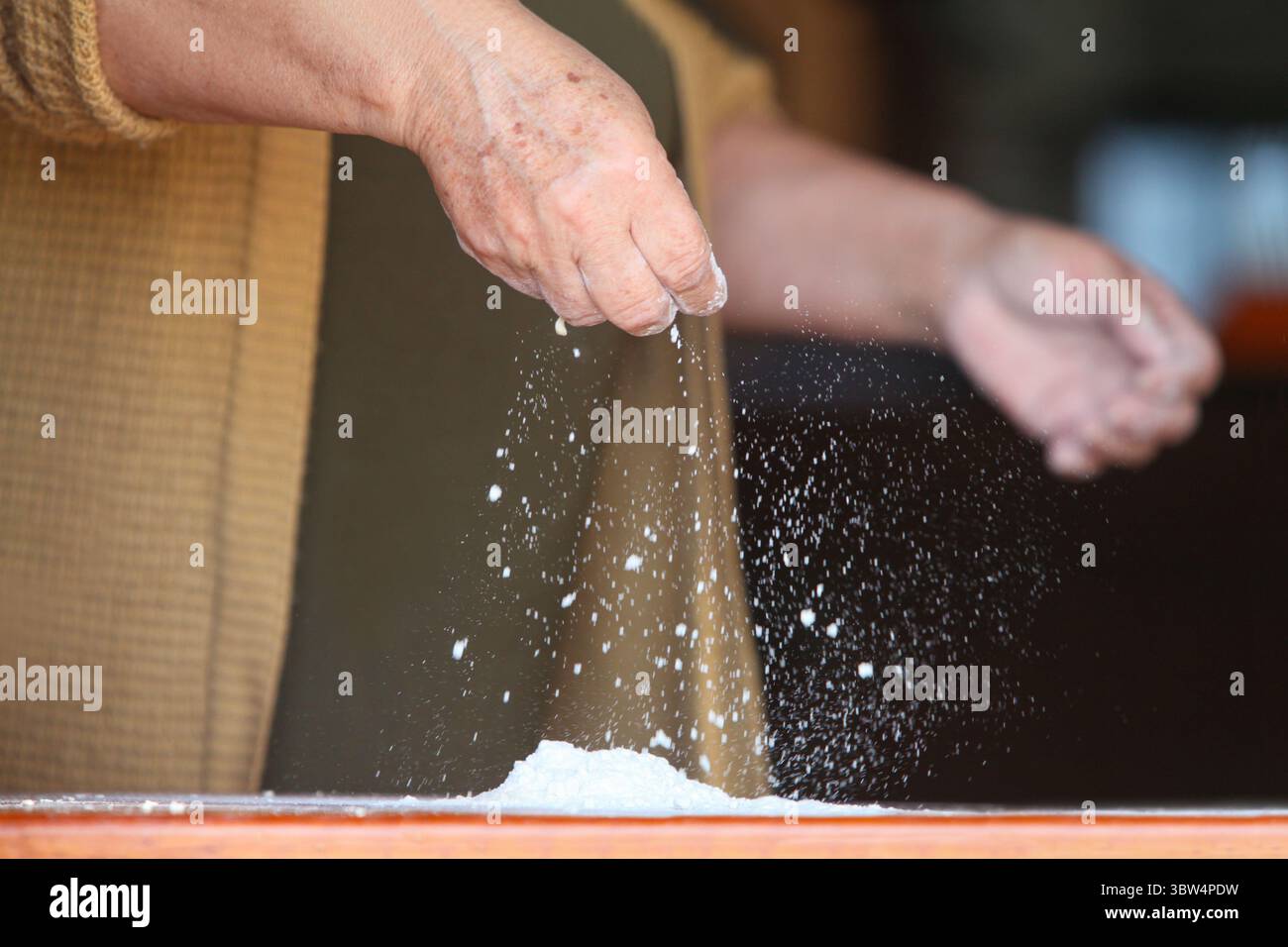 femme latino, dans ses 60 ans, habillée décontractée à la maison, faisant de la pâte à la main dans une cuisine simple. Elle a un aspect naturel natif, incarnant tous les jours Banque D'Images