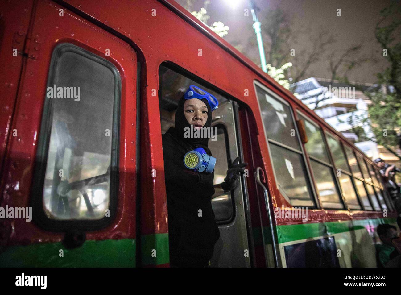 8 novembre 2020, Bangkok, Thaïlande : un manifestant pro-démocratie a vu surveiller la manifestation depuis l'intérieur d'un bus de la ville lors d'une manifestation antigouvernementale dans la capitale thaïlandaise. Les manifestants pro-démocratie sont descendus dans les rues au Monument de la démocratie pour marcher vers le Grand Palais pour remettre une lettre au roi de Thaïlande Maha Vajiralongkorn (Rama X), les manifestants ont été accueillis par la police thaïlandaise qui a utilisé des bus urbains et des barbelés pour bloquer la route, et des canons à eau pour disperser la foule à Sanam Luang devant le Grand Palais. (Crédit image : © Geem Drake/SOPA images via ZUMA Wire) Banque D'Images
