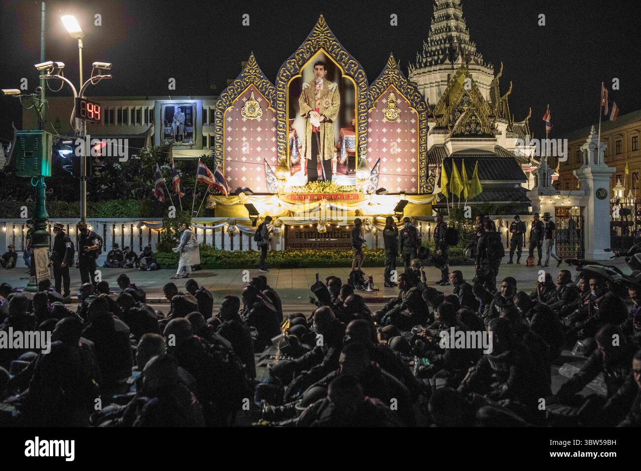 8 novembre 2020, Bangkok, Thaïlande : des policiers anti-émeute vus se reposer devant un portrait du roi de Thaïlande Maha Vajiralongkorn (Rama X) lors d'une manifestation anti-gouvernementale dans la capitale thaïlandaise. Les manifestants pro-démocratie sont descendus dans les rues au Monument de la démocratie pour marcher vers le Grand Palais pour remettre une lettre au roi de Thaïlande Maha Vajiralongkorn (Rama X), les manifestants ont été accueillis par la police thaïlandaise qui a utilisé des bus urbains et des barbelés pour bloquer la route, et des canons à eau pour disperser la foule à Sanam Luang devant le Grand Palais. (Crédit image : © Geem Drake/SOPA images via ZUMA Wire) Banque D'Images