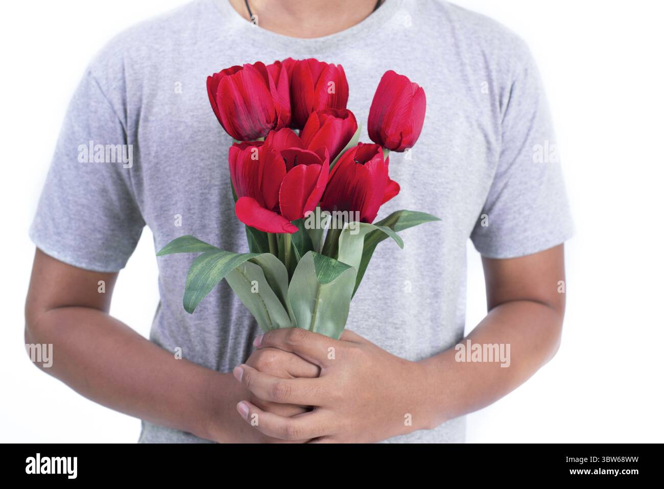 Homme tenant la fleur de rose rouge. Saint Valentin et concept de couples. Thème amour et flirt. Gros plan à rose. Partie du corps et thème sans tête Banque D'Images