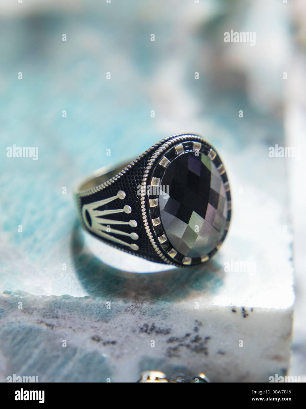 Bague en argent pour hommes avec un design orné et un grand bijou noir au centre Banque D'Images