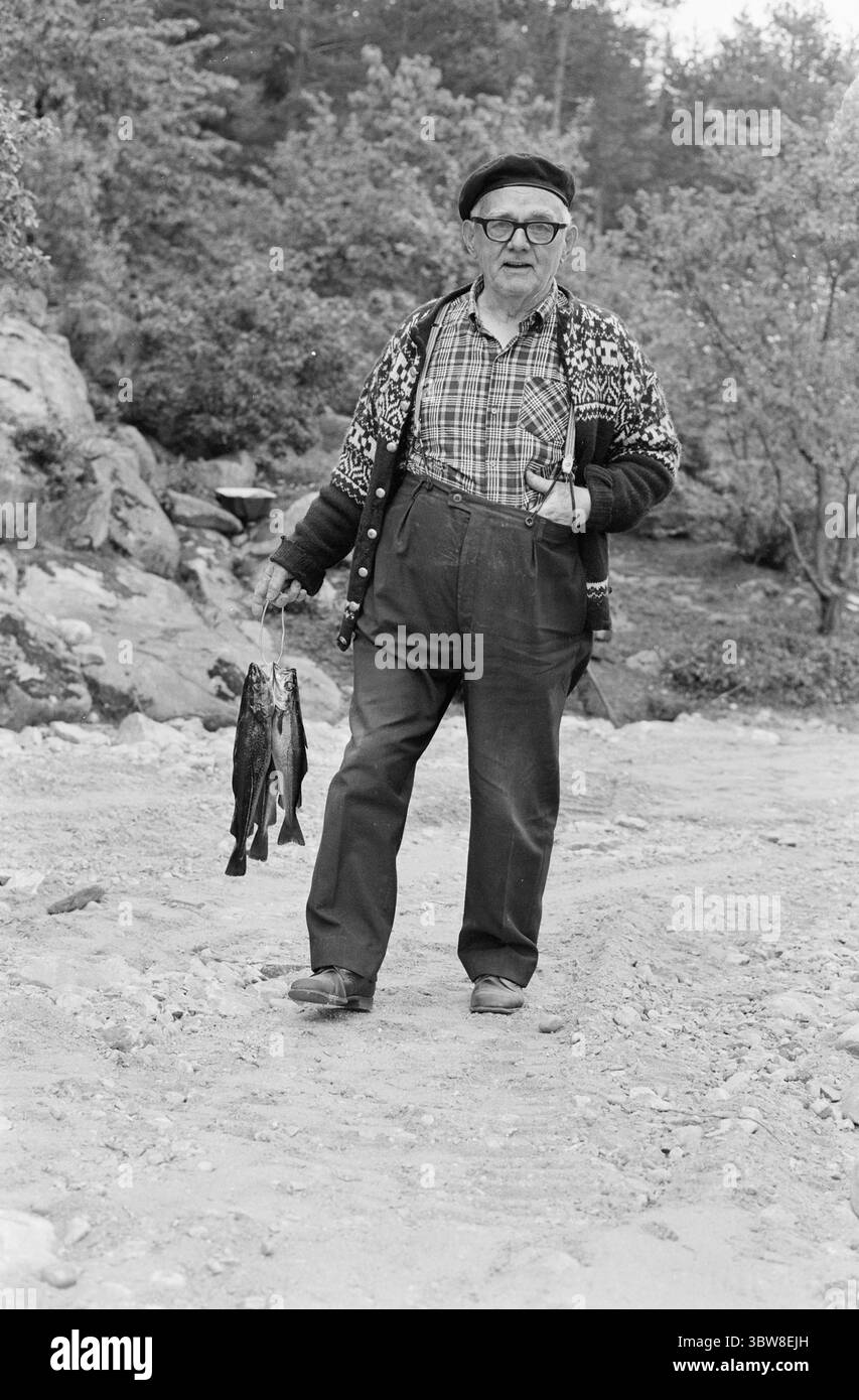 Aktuell 26 - 6 - 1970 : L'été du sud de la Norvège attend. Nous avons fait une visite éphémère de la plage à l'un des paradis de vacances du sud de la Norvège, Brekkestø, et pouvons vous le signaler : les campings, les maisons d'hôtes et les résidents locaux attendent la grande invasion de vacances de l'été. Attente avec le soleil, cuisson Svaberg et la morue qui vont au leurre et filet. Sven Arthur Haavik, 77 ans, prouve que la morue va volontiers au leurre dans le détroit. Il tire le leurre avec l'aide d'une boîte de bol de poisson, et il obtient du poisson. Haavik est un marin à la retraite, il a navigué pendant deux guerres mondiales, mais a trouvé une vie paisible qui Banque D'Images