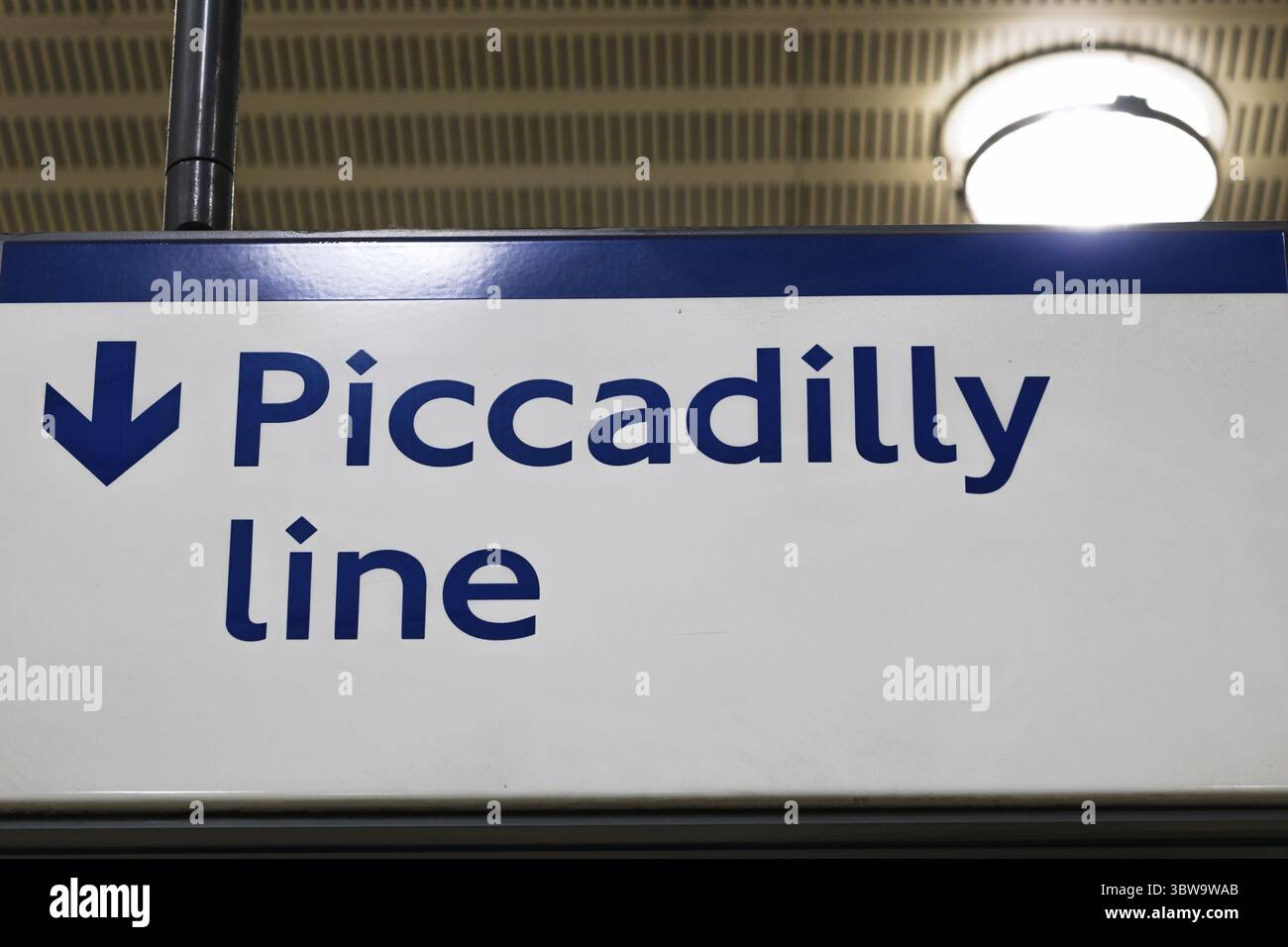 Piccadilly Line signe avec flèche vers le bas dans la station de métro de Londres, guidant efficacement les passagers Banque D'Images