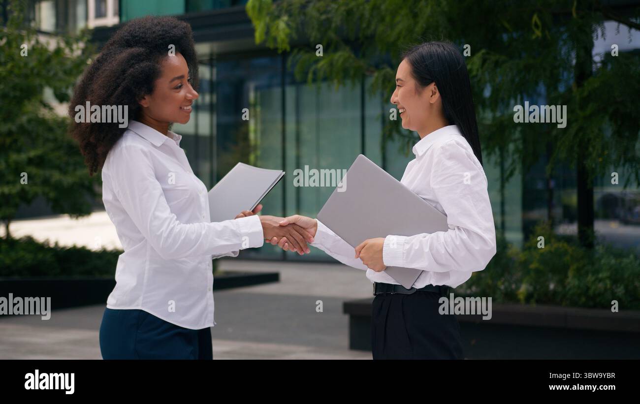 Afro-américaine asiatique coréenne femmes poignée de main rencontre saluer femmes d'affaires collègues collègues collègues partenaires affaire dossier documents contrat Banque D'Images