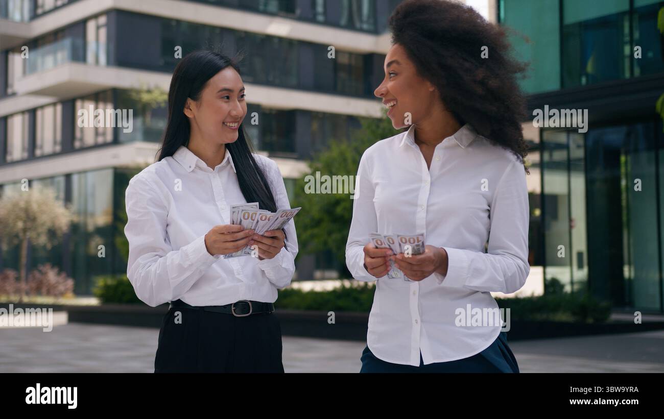 Heureux afro-américain asiatique coréen femmes d'affaires femmes collègues collègues partenaires de travail affaire profiter des employés compter argent salaire en espèces Banque D'Images