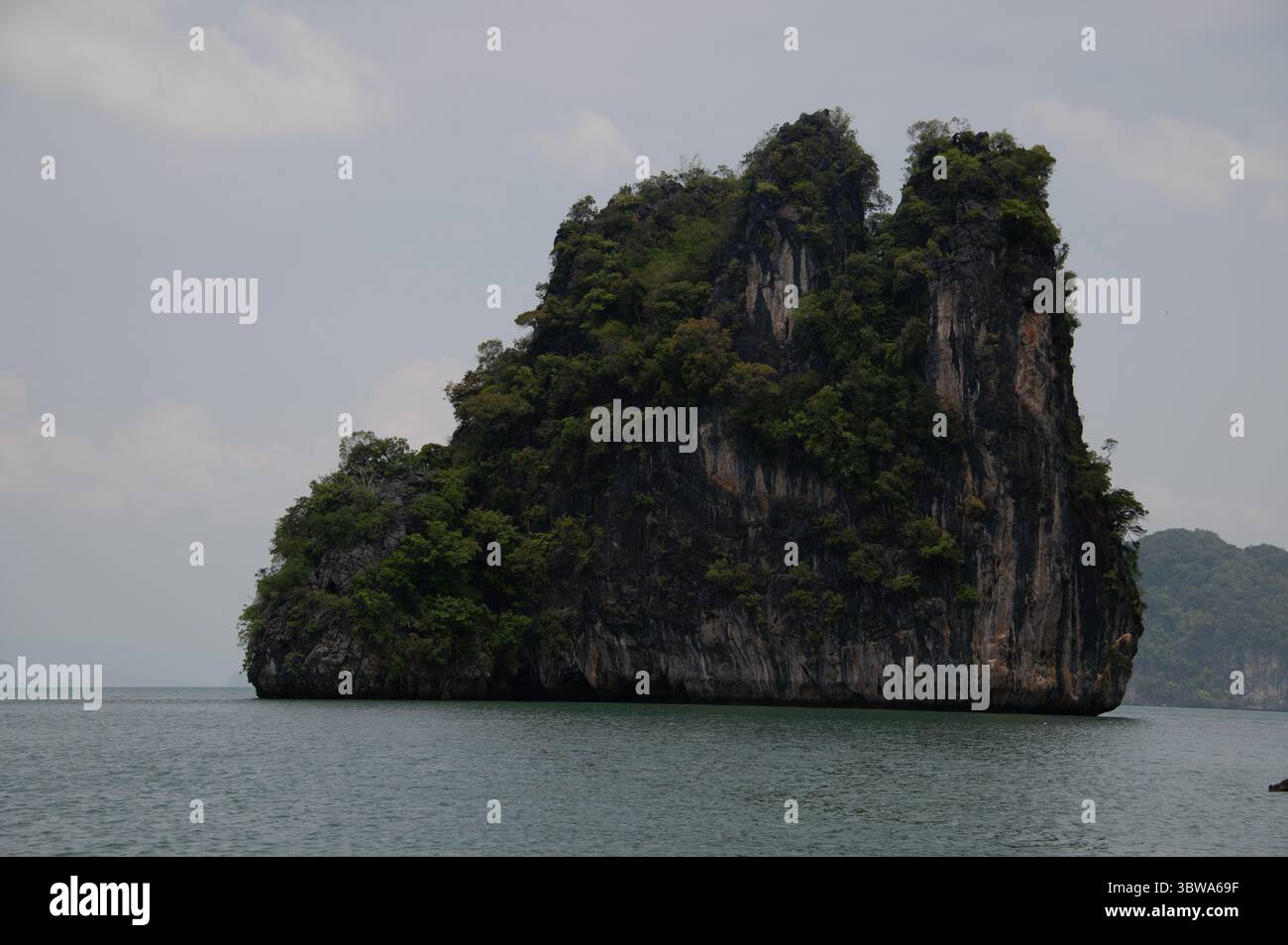 L'une des nombreuses petites îles calcaires inhabitées recouvertes de jungle dispersées autour de la baie de Phang Nga dans la mer d'Andaman, au sud de la Thaïlande. L'île Banque D'Images