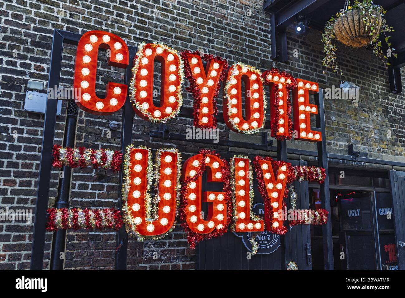 Signe moche de coyote avec des lumières de marquise rouges sur le mur de briques à Camden. Londres, Royaume-Uni, 26 décembre 2023 Banque D'Images