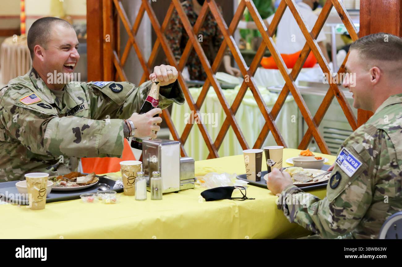 26 novembre 2020, Camp Bondsteel, Kosovo : le Major JOSEPH WHALEN de la Garde nationale de l'armée de l'Iowa partage une bouteille de jus de raisin pétillant avec un collègue lors d'un repas de Thanksgiving au Camp Bondsteel, Kosovo. Les soldats servant dans le Commandement régional-est dans le cadre de Kosovo Force 28 ont célébré la fête tout en suivant les directives du CDC pour COVID-19. (Crédit image : © Sgt. Tawny Schmit/U.S. Armée via ZUMA Wire/ZUMAPRESS.com) Banque D'Images