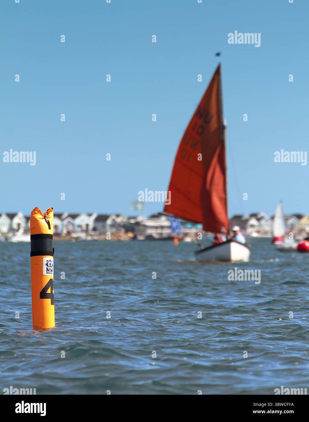 Bateau à voile, voilier approchant Une marque flottante gonflable au vent lors D'Une régate de voile sur le port de Christchurch, Royaume-Uni, concept Hobby, Fun, Comp Banque D'Images