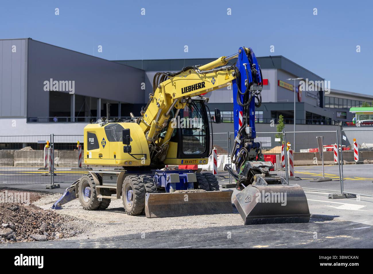 Wickrange, Luxembourg - vue sur une pelle sur roues jaune Liebherr A 918 Compact pour travaux de terrassement sur un chantier. Banque D'Images