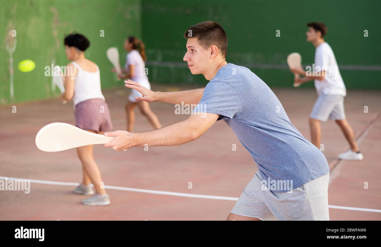 Jeune homme servant le ballon pendant le jeu de pelota à l'extérieur Banque D'Images