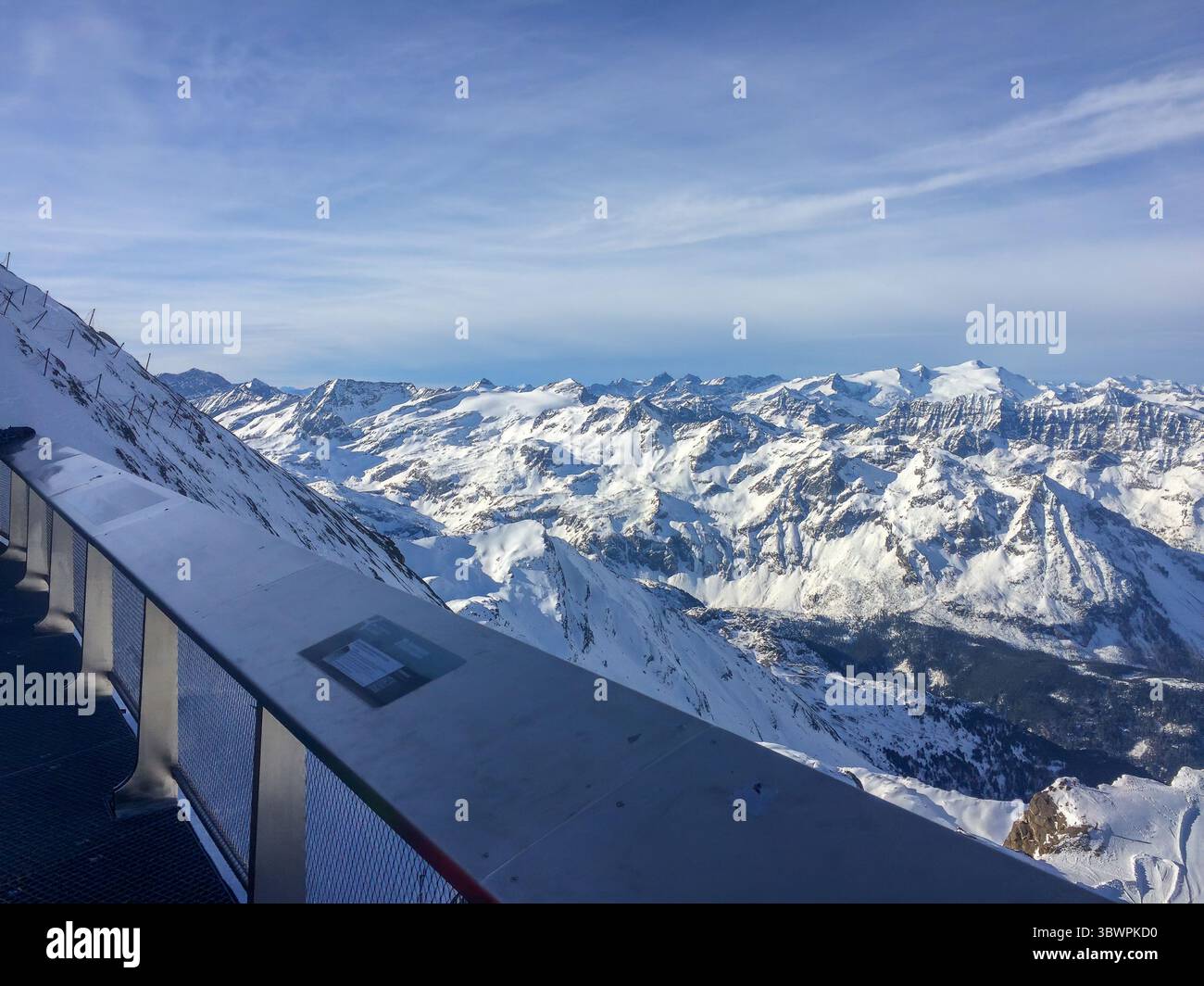 Paysage alpin près de Uttendorf, Salzbourg, Autriche, avec des pentes de montagne vertes, route sinueuse et ciel nuageux d'été. Banque D'Images