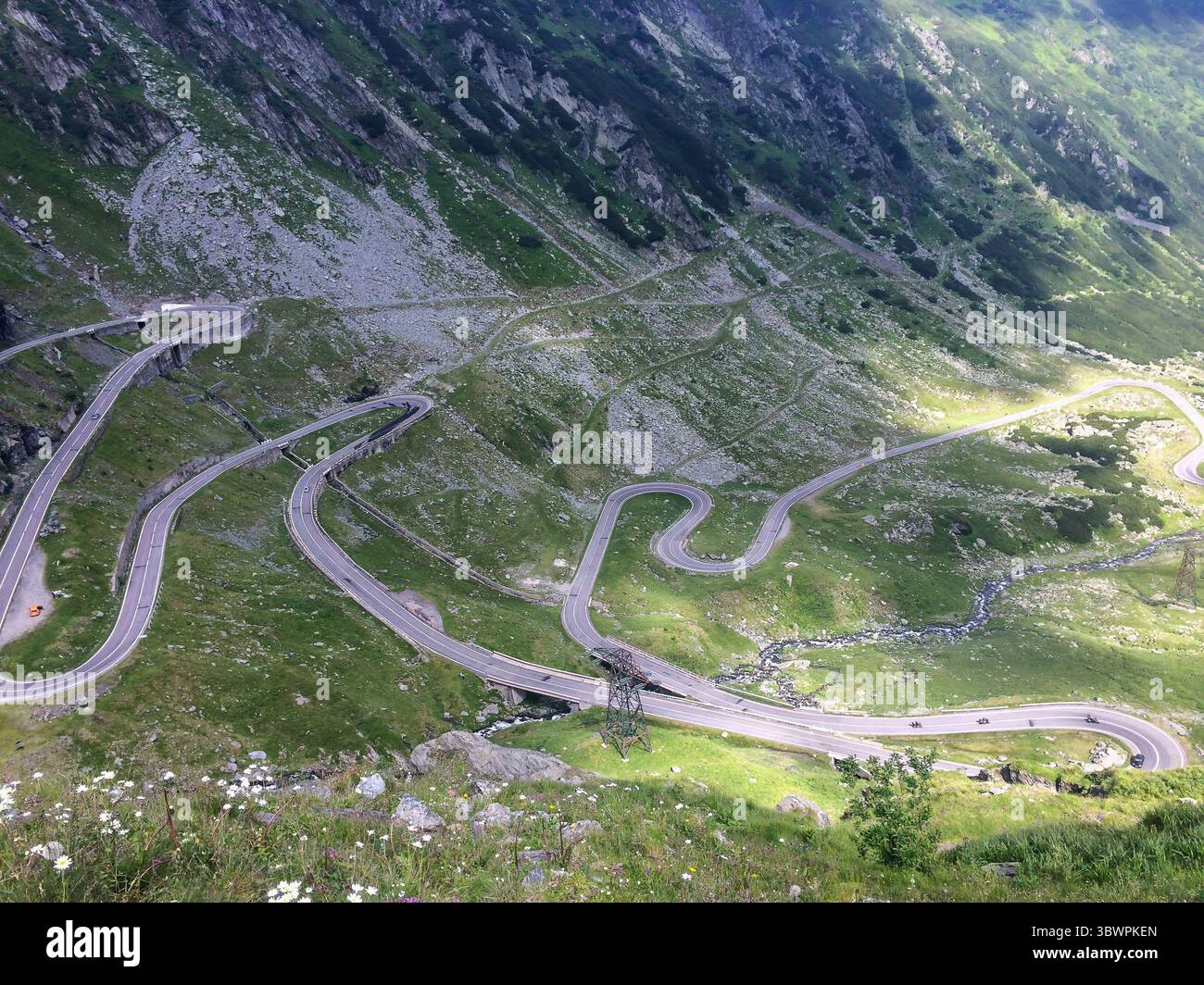 Vue aérienne de la route sinueuse du Transfagarasan en Roumanie, montrant des courbes serrées et un terrain alpin escarpé dans les Carpates. Banque D'Images