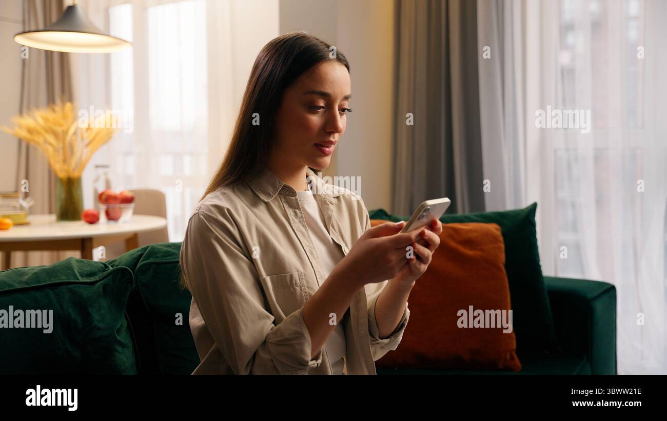 Femme caucasienne utilisant un téléphone portable à la maison fille concentrée chattant texting smartphone chat service de réservation de commande de nourriture dans la vie Banque D'Images