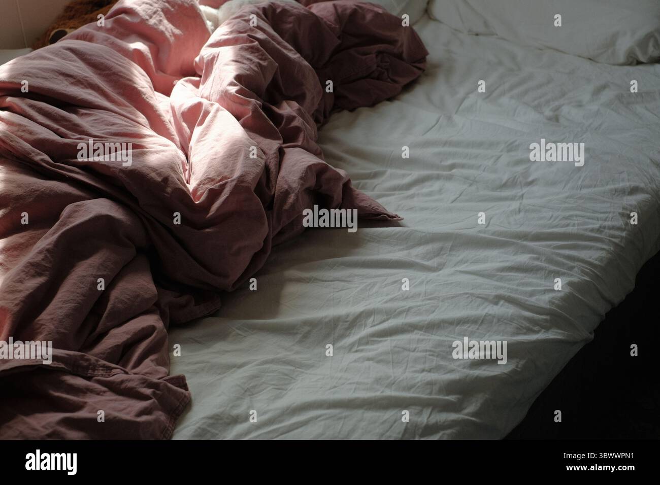 draps roses froissés sur un lit douillet Banque D'Images