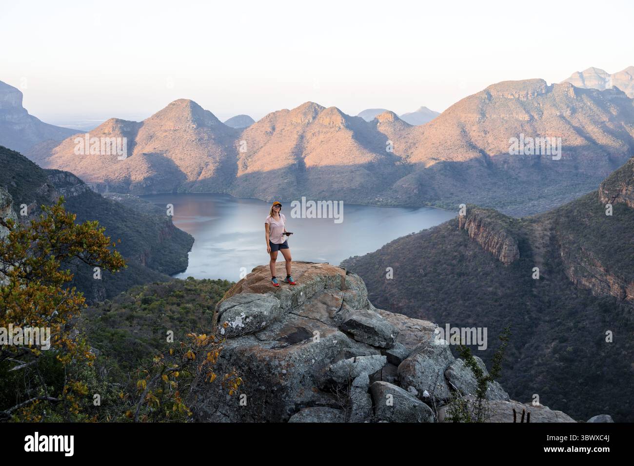 Randonneur profitant du coucher du soleil à Blyde River Canyon, vue sur le canyon avec Blyde River dans la lumière du soir, paysage du canyon, Panorama route, Mpumalanga, Sud Banque D'Images