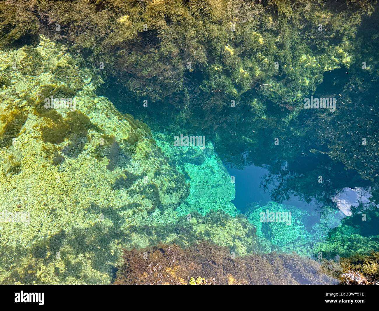Source karstique naturelle avec eau turquoise transparente et rochers sous-marins en Sardaigne Banque D'Images