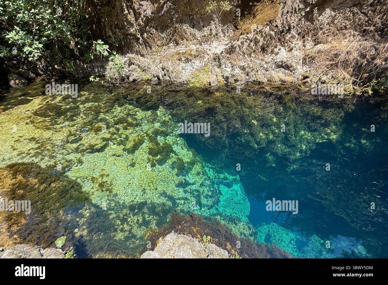 Source karstique naturelle avec eau turquoise transparente et rochers sous-marins en Sardaigne Banque D'Images