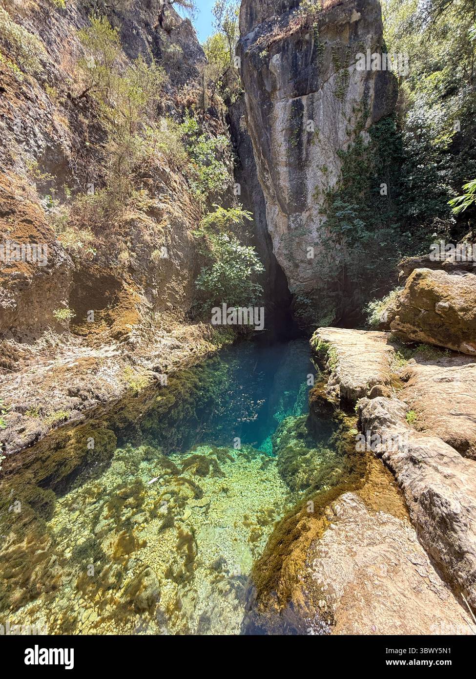 Source karstique naturelle avec eau turquoise transparente et rochers sous-marins en Sardaigne Banque D'Images
