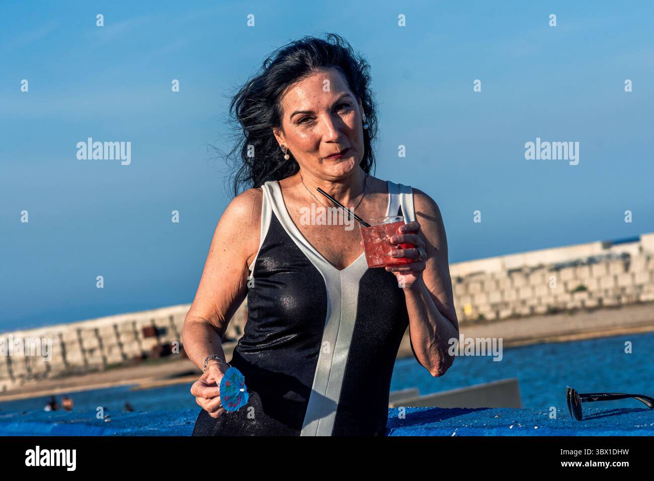 Mannequin senior profitant d'un cocktail au bord de la mer, embrassant la positivité corporelle et l'inclusion Banque D'Images Mannequin senior profitant d'un cocktail au bord de la mer, embrassant la positivité corporelle et l'inclusion Banque D'Images