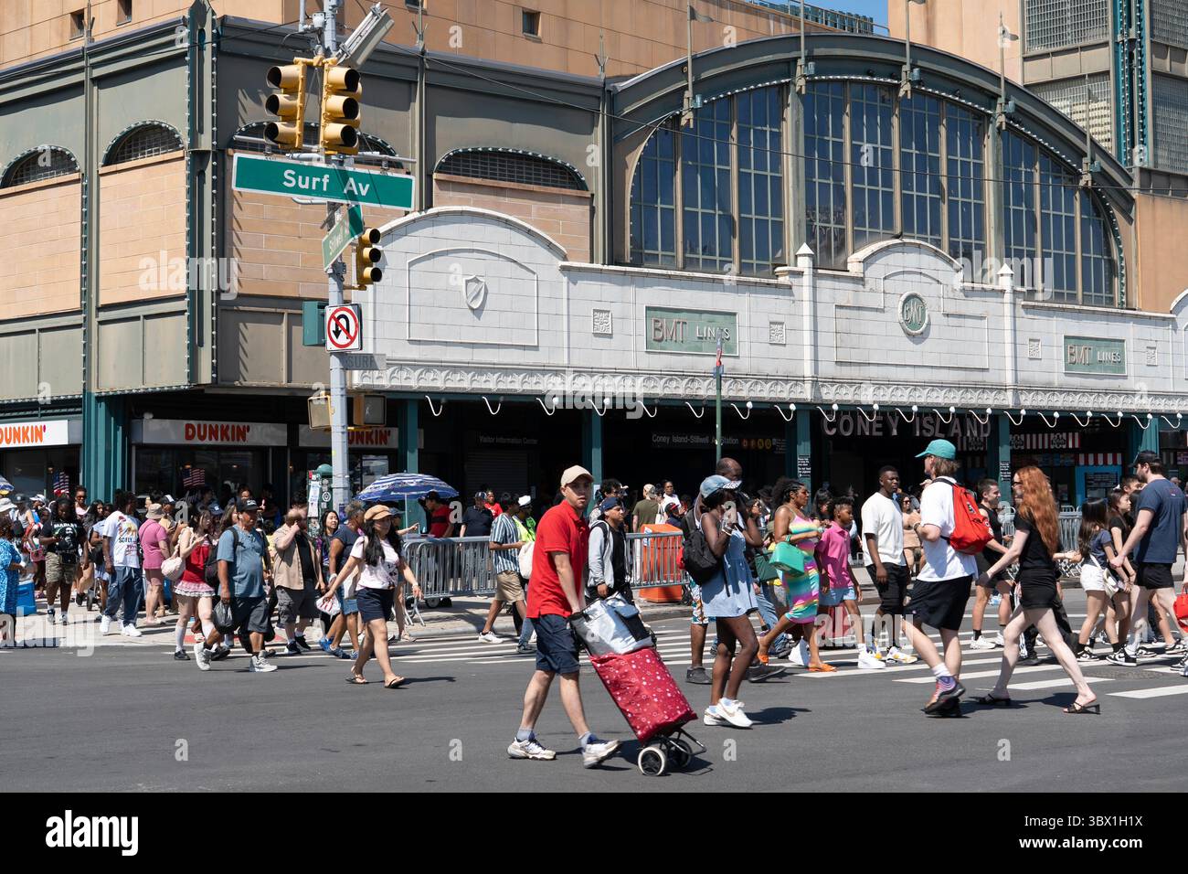 Des foules de Beach Goers traversant Surf Avenue depuis la station de métro Stillwell Avenue à Coney Island, Brooklyn, New York. Banque D'Images