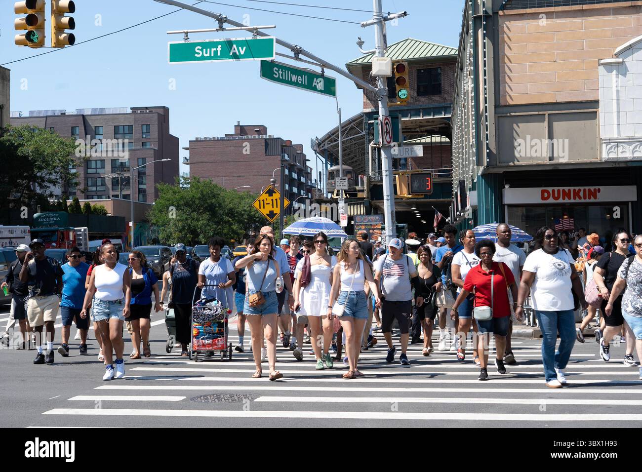 Des foules de Beach Goers traversant Surf Avenue depuis la station de métro Stillwell Avenue à Coney Island, Brooklyn, New York. Banque D'Images