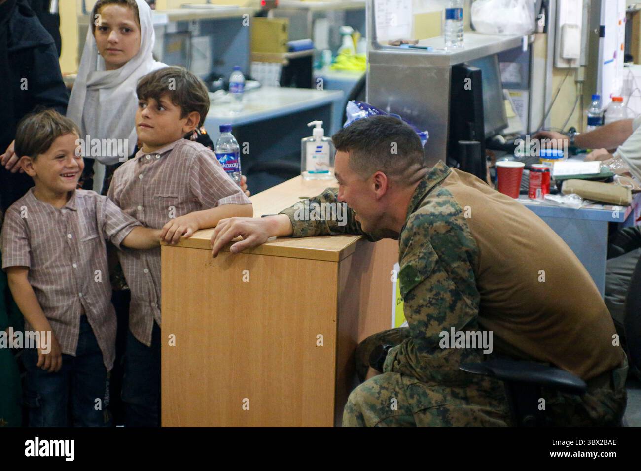 18 août 2021, Kaboul, Afghanistan : un Marine américain affecté à la 24e unité expéditionnaire des Marines interagit avec des enfants lors d'une évacuation à l'aéroport international Hamid Karzai. Les Marines américains aident le Département d'État à évacuer l'aéroport international Hamid Karzai. (Crédit image : © Nicholas Guevara/U.S. Marines/ZUMA Press Wire Service) Banque D'Images