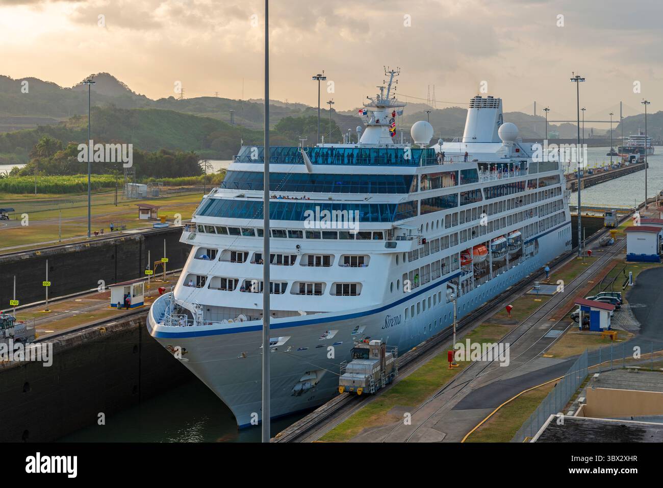 Bateau de croisière passant les écluses de Miraflores du canal de Panama au coucher du soleil dans la ville de Panama, Panama. Banque D'Images