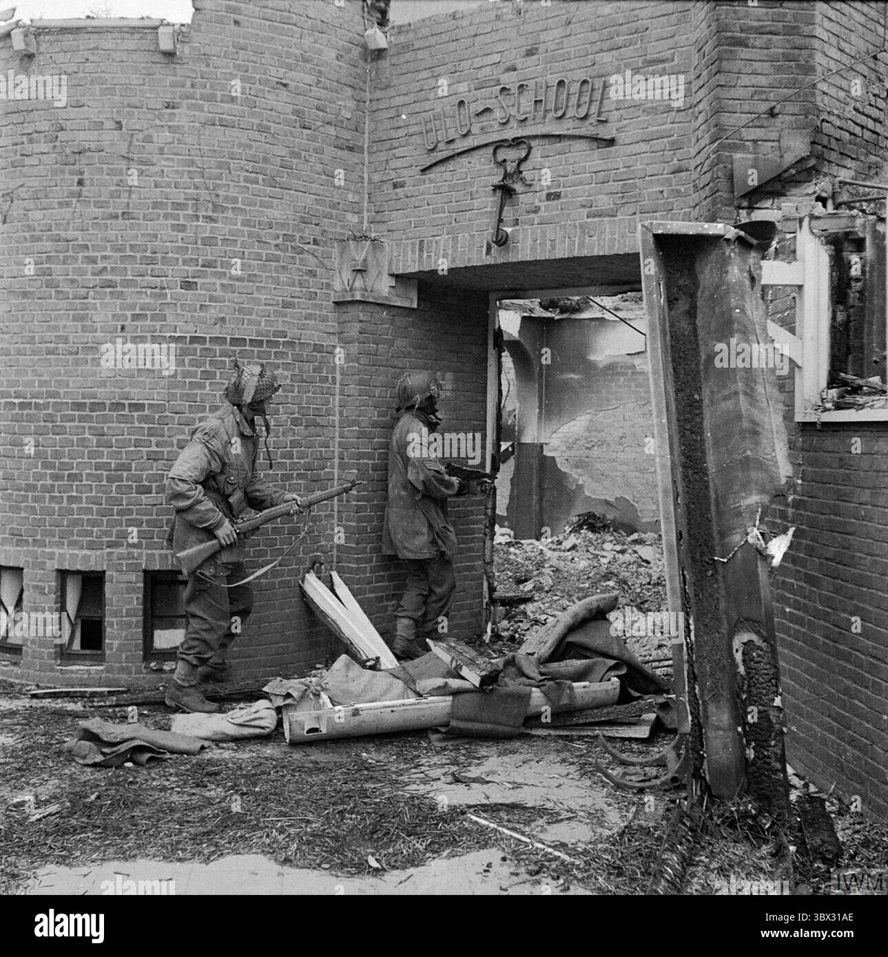 OOSTERBEEK, PAYS-BAS - 20 septembre 1944 - Une école néerlandaise endommagée par des tirs de mortier, fouillée à la recherche de tireurs d'élite allemands par le sergent J Whawell et S. Banque D'Images