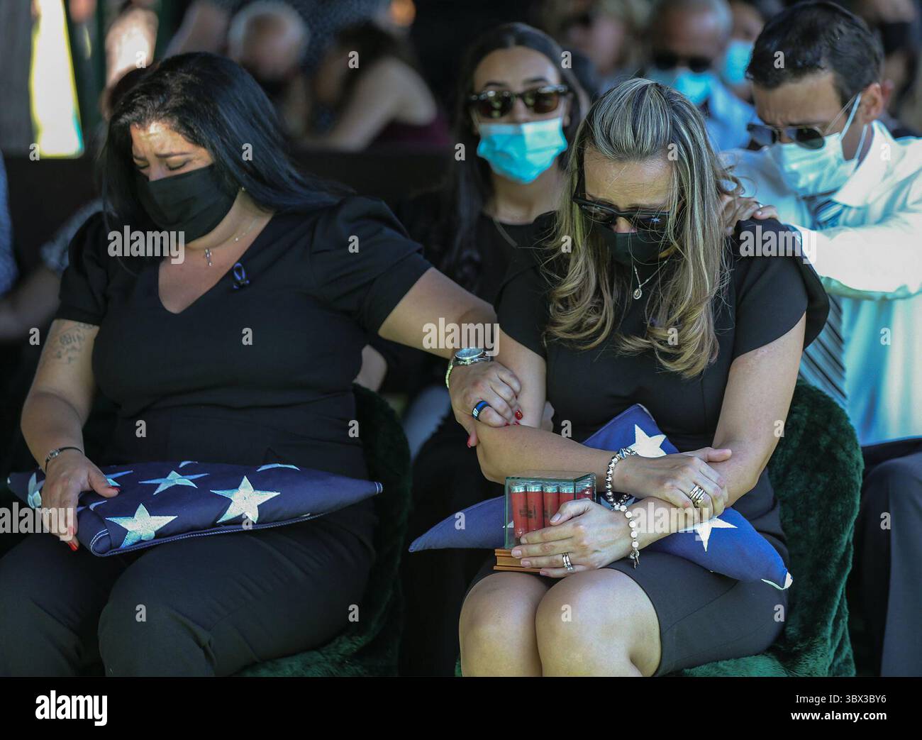 23 août 2021, Miami, Floride, États-Unis : Luisa Febles, L'épouse du cavalier de la patrouille routière de Floride Lazaro R. Febles, est réconfortée par sa belle-sœur Bianca Gonzalez et son beau-frère Jorge Botero au cimetière Woodlawn Park dans le sud-ouest de Miami-Dade le vendredi 20 août 2021. Febles a servi plus de 11 ans avec la Florida Highway Patrol dans la Troop E Miami, il est mort des complications de COVID-19. (Crédit image : © Al Diaz/TNS via ZUMA Press Wire/TNS via ZUMA Press Wire) Banque D'Images