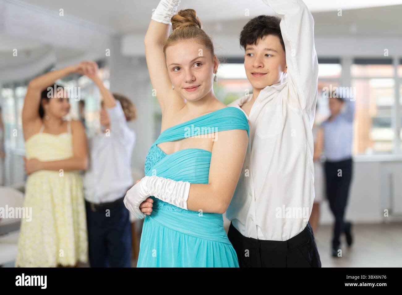 Positif adolescent garçon et fille dansent la version classique de valse en couple pendant la leçon au studio Banque D'Images