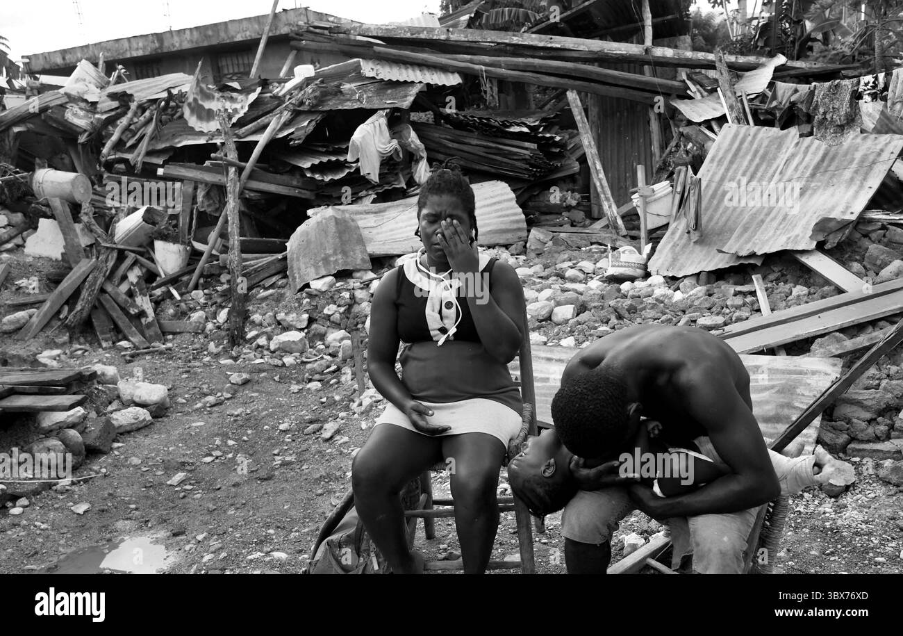 27 août 2021, Maniche, Haïti : S’il y a de la vie, il y a hopeâ€™ â€“ Chrislome Lorbensky, survivant. Chrislome Lorbensky et son épouse Altema Rosenine avec leur fils de 11 mois Adonia Ande Lorbensky, surnommé ton ton, font face aux conséquences d’un ouragan massif à Maniche, Haïti le 27 août 2021. Rosenine pleure pendant une interview alors qu'elle parle d'Adonia Ande Lorbensky, la fille qu'elle pleure, ..ils ont perdu leur fille de 3 ans dans le séisme et s'accrochent à leur bébé survivant avec un plâtre sur sa jambe cassée. Il a été retrouvé sous le cadavre de son oncle sur ce terrain où ils s'efforcent de le faire Banque D'Images