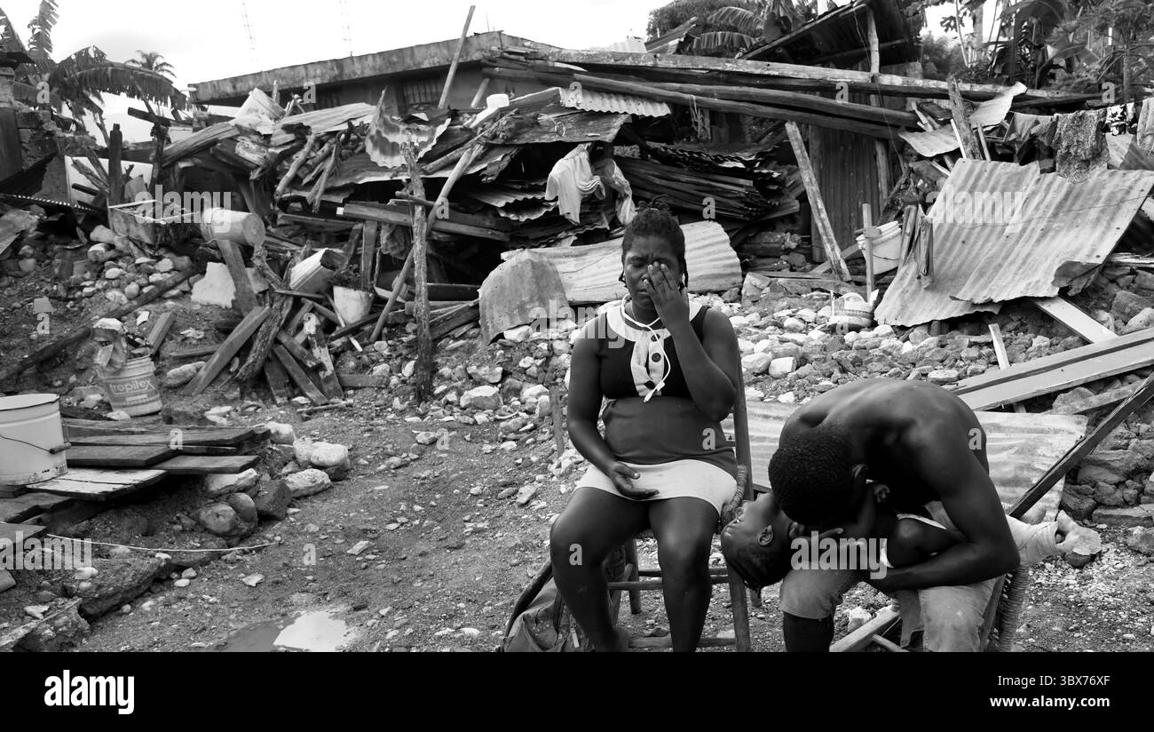 27 août 2021, Maniche, Haïti : S’il y a de la vie, il y a hopeâ€™ â€“ Chrislome Lorbensky, survivant. Chrislome Lorbensky et son épouse Altema Rosenine avec leur fils de 11 mois Adonia Ande Lorbensky, surnommé ton ton, font face aux conséquences d’un ouragan massif à Maniche, Haïti le 27 août 2021. Rosenine pleure pendant une interview alors qu'elle parle d'Adonia Ande Lorbensky, la fille qu'elle pleure, ..ils ont perdu leur fille de 3 ans dans le séisme et s'accrochent à leur bébé survivant avec un plâtre sur sa jambe cassée. Il a été retrouvé sous le cadavre de son oncle sur ce terrain où ils s'efforcent de le faire Banque D'Images