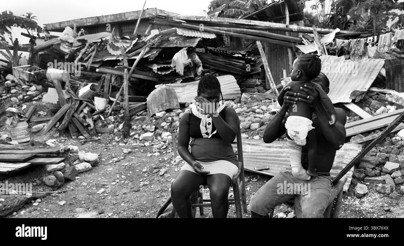 27 août 2021, Maniche, Haïti : S’il y a de la vie, il y a hopeâ€™ â€“ Chrislome Lorbensky, survivant. Chrislome Lorbensky et son épouse Altema Rosenine avec leur fils de 11 mois Adonia Ande Lorbensky, surnommé ton ton, font face aux conséquences d’un ouragan massif à Maniche, Haïti le 27 août 2021. Rosenine pleure pendant une interview alors qu'elle parle d'Adonia Ande Lorbensky, la fille qu'elle pleure, ..ils ont perdu leur fille de 3 ans dans le séisme et s'accrochent à leur bébé survivant avec un plâtre sur sa jambe cassée. Il a été retrouvé sous le cadavre de son oncle sur ce terrain où ils s'efforcent de le faire Banque D'Images