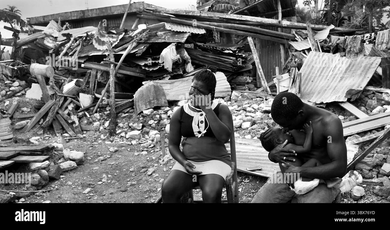 27 août 2021, Maniche, Haïti : S’il y a de la vie, il y a hopeâ€™ â€“ Chrislome Lorbensky, survivant. Chrislome Lorbensky et son épouse Altema Rosenine avec leur fils de 11 mois Adonia Ande Lorbensky, surnommé ton ton, font face aux conséquences d’un ouragan massif à Maniche, Haïti le 27 août 2021. Rosenine pleure pendant une interview alors qu'elle parle d'Adonia Ande Lorbensky, la fille qu'elle pleure, ..ils ont perdu leur fille de 3 ans dans le séisme et s'accrochent à leur bébé survivant avec un plâtre sur sa jambe cassée. Il a été retrouvé sous le cadavre de son oncle sur ce terrain où ils s'efforcent de le faire Banque D'Images