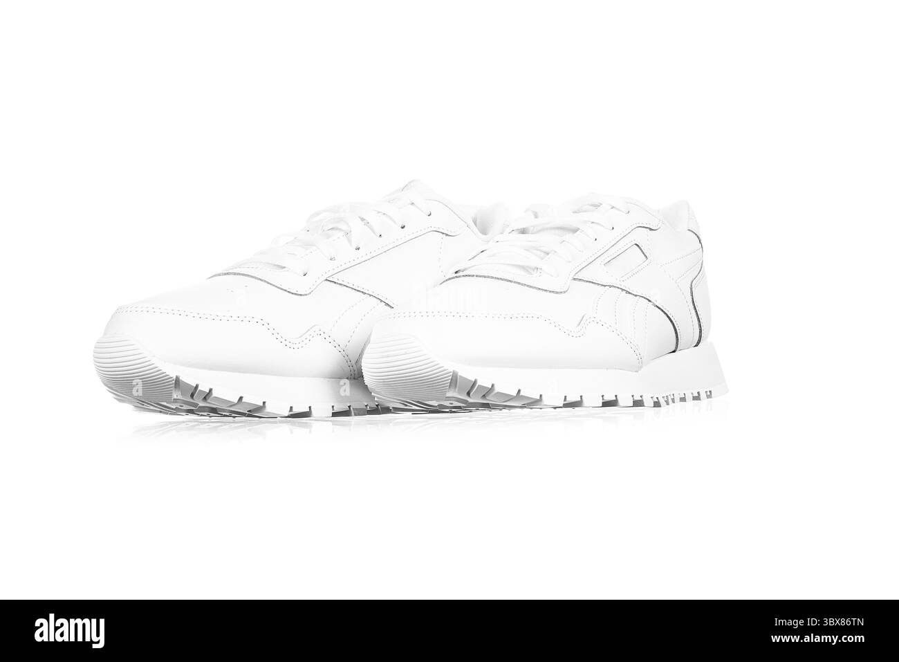 Baskets féminines en cuir blanc isolées sur fond blanc. Chaussures de sport tendance et décontractées. Banque D'Images