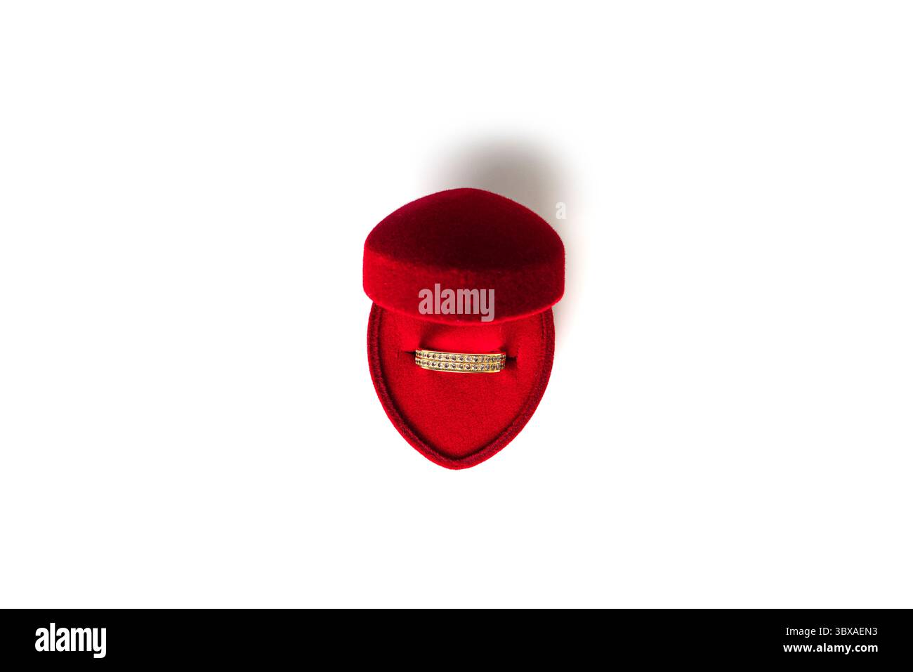Bague de mariage en or dans une boîte à bijoux en forme de coeur rouge isolé sur un fond blanc. Photo de haute qualité Banque D'Images Bague de mariage en or dans une boîte à bijoux en forme de coeur rouge isolé sur un fond blanc. Photo de haute qualité Banque D'Images