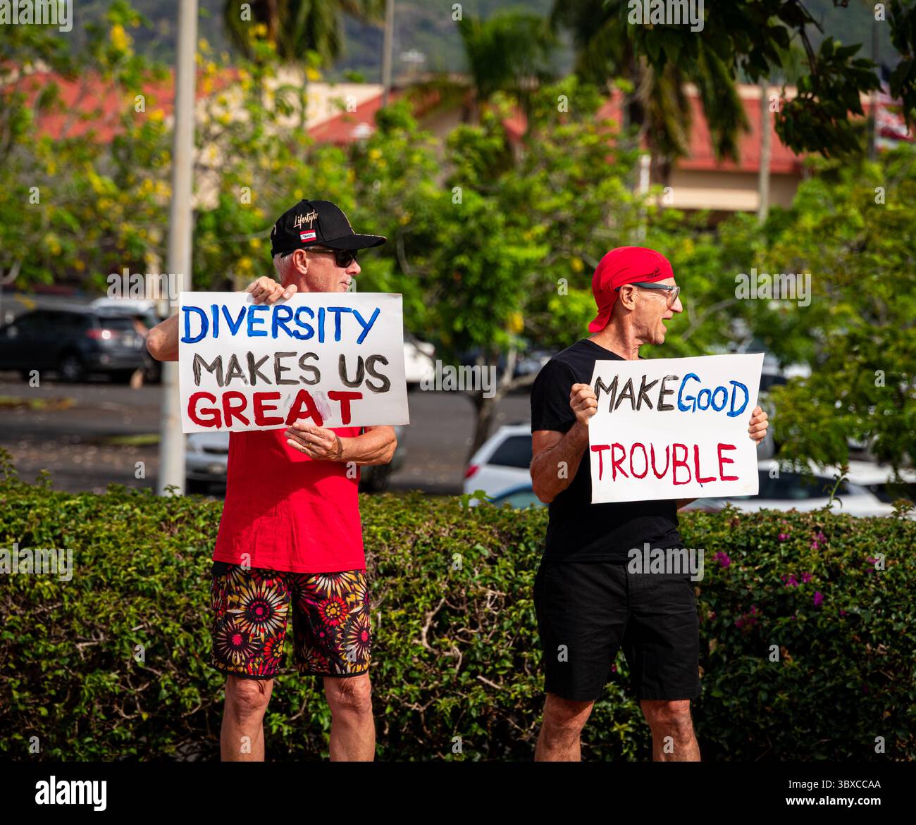 Deux manifestants avec des pancartes manifestent sur le trottoir du rassemblement Make Good trouble au Kukui Grove Mall. Banque D'Images