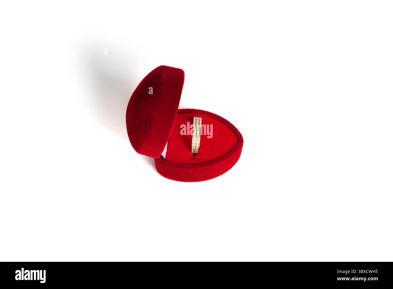 Bague de mariage en or dans une boîte à bijoux en forme de coeur rouge isolé sur un fond blanc. Photo de haute qualité Banque D'Images Bague de mariage en or dans une boîte à bijoux en forme de coeur rouge isolé sur un fond blanc. Photo de haute qualité Banque D'Images