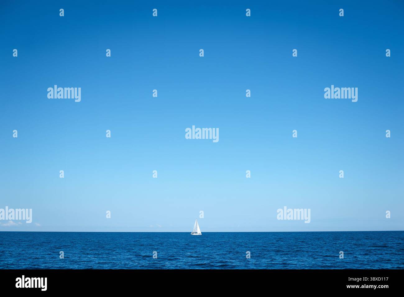 Voilier solitaire sur un océan calme Banque D'Images