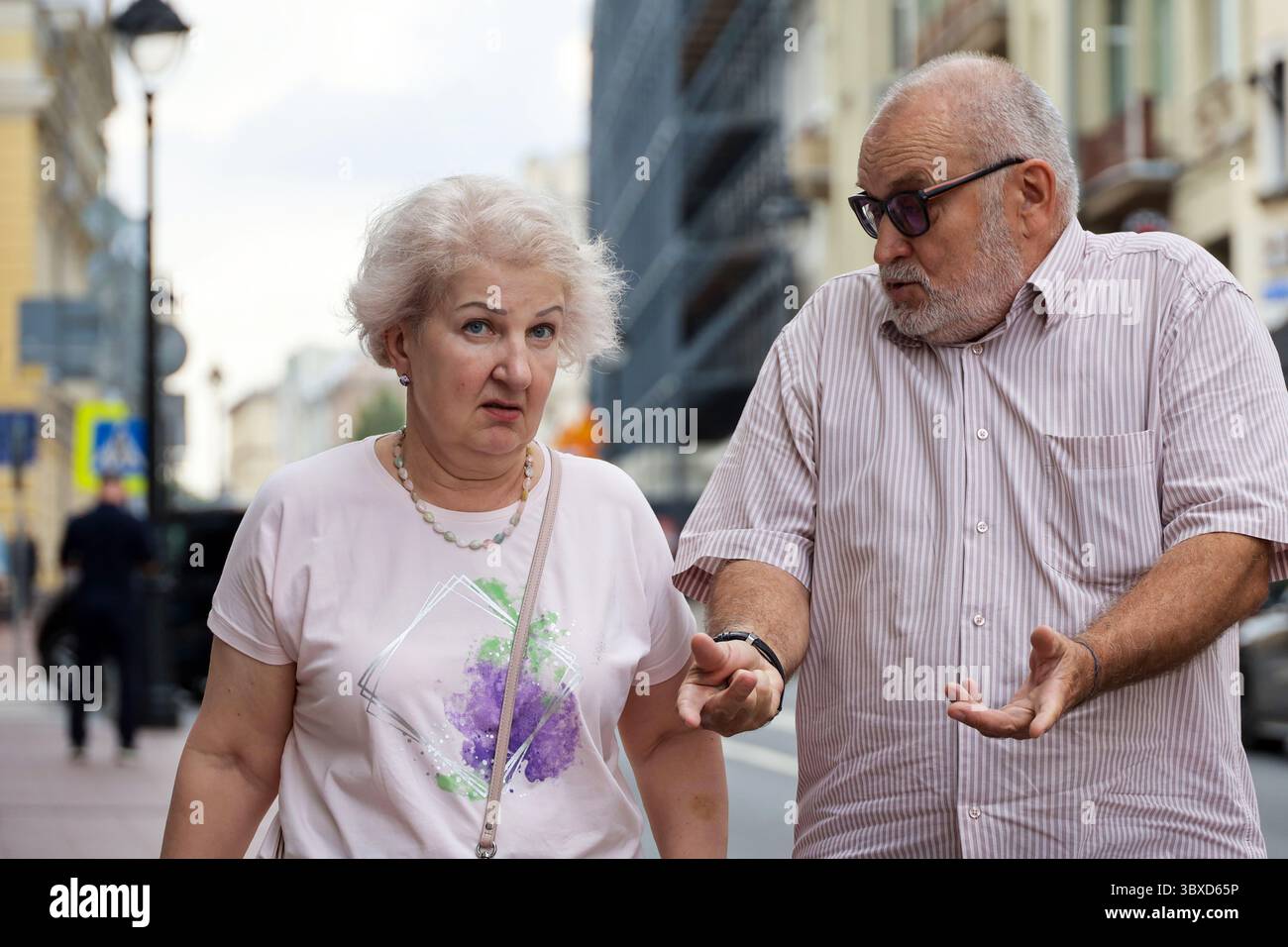 Moscou, Russie - 16 juillet 2025 : vieux couple parlant émotionnellement dans la rue de la ville en été Banque D'Images