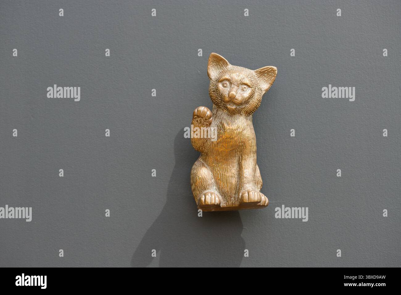 Japonais, chinois et asiatique, figure d'un chat ondulant est pensé pour apporter de la chance. Une patte vers le haut dans un geste d'insigne. Heurtoir de porte. Banque D'Images