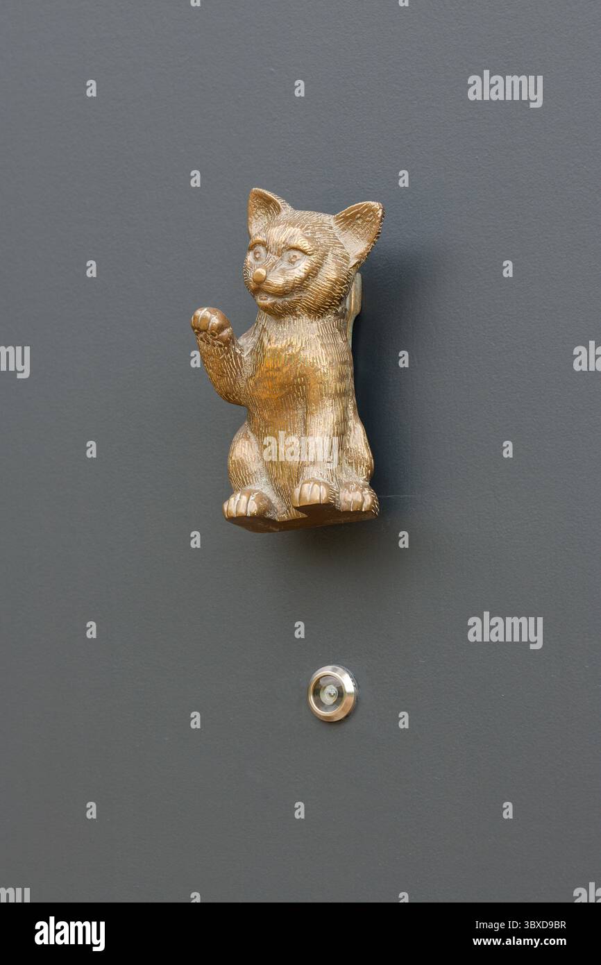 Japonais, chinois et asiatique, figure d'un chat ondulant est pensé pour apporter de la chance. Une patte vers le haut dans un geste d'insigne. Heurtoir de porte. Banque D'Images